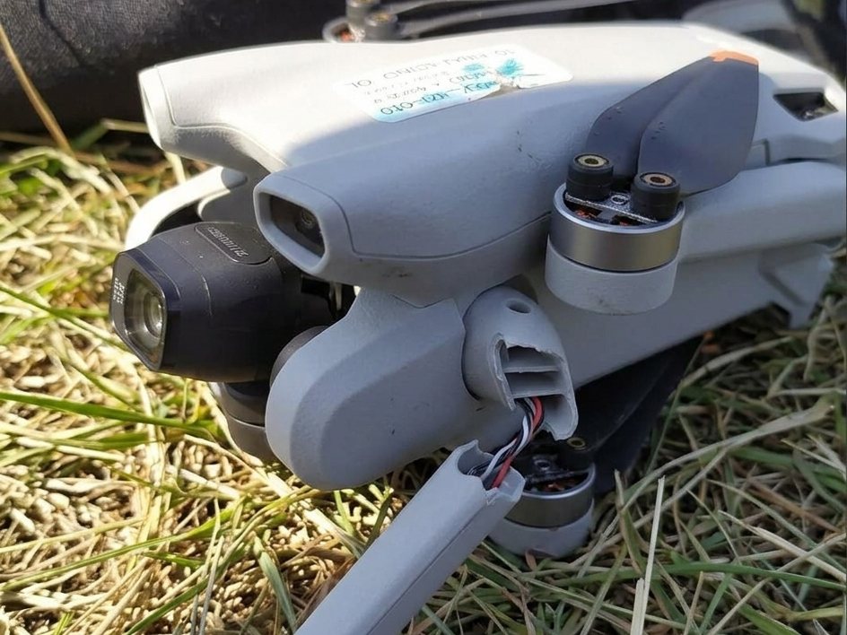 Drone with a snapped arm lying in the grass after a crash